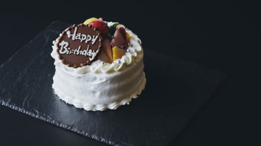 フルーツを飾ったメッセージ入りホールケーキ。誕生日や記念日のお祝い向け