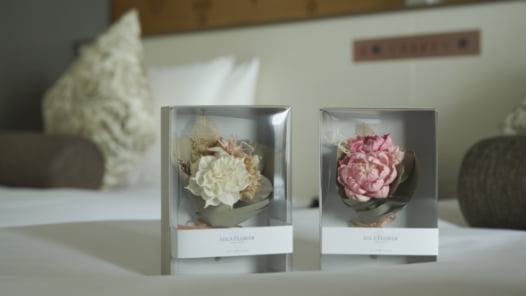 ピンクの花びらに包まれた一輪ブーケのギフト。結婚記念日に想いを伝える演出イメージ
