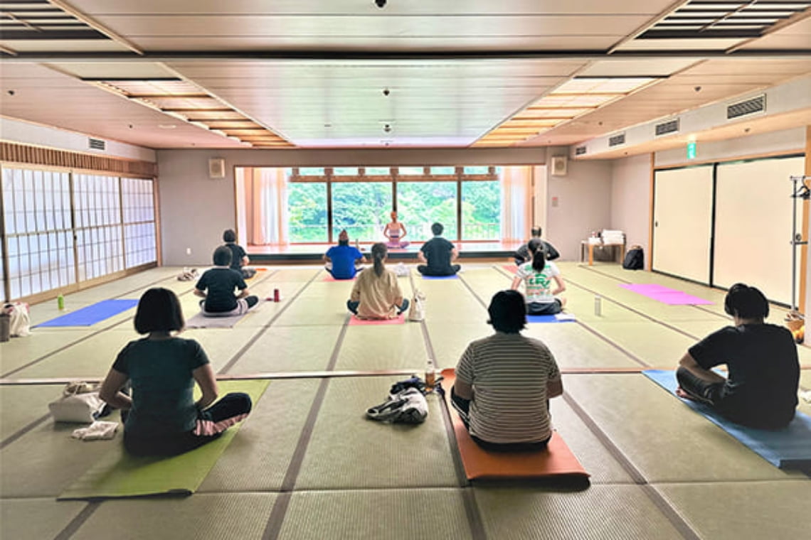 和室で地域住民が参加するヨガ体験教室の様子。自然光が差し込む空間でリラックスして座る参加者たち