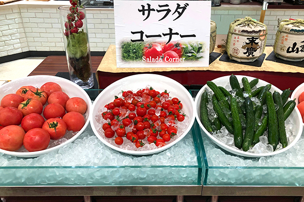 氷の上に白い大皿に盛った夏野菜